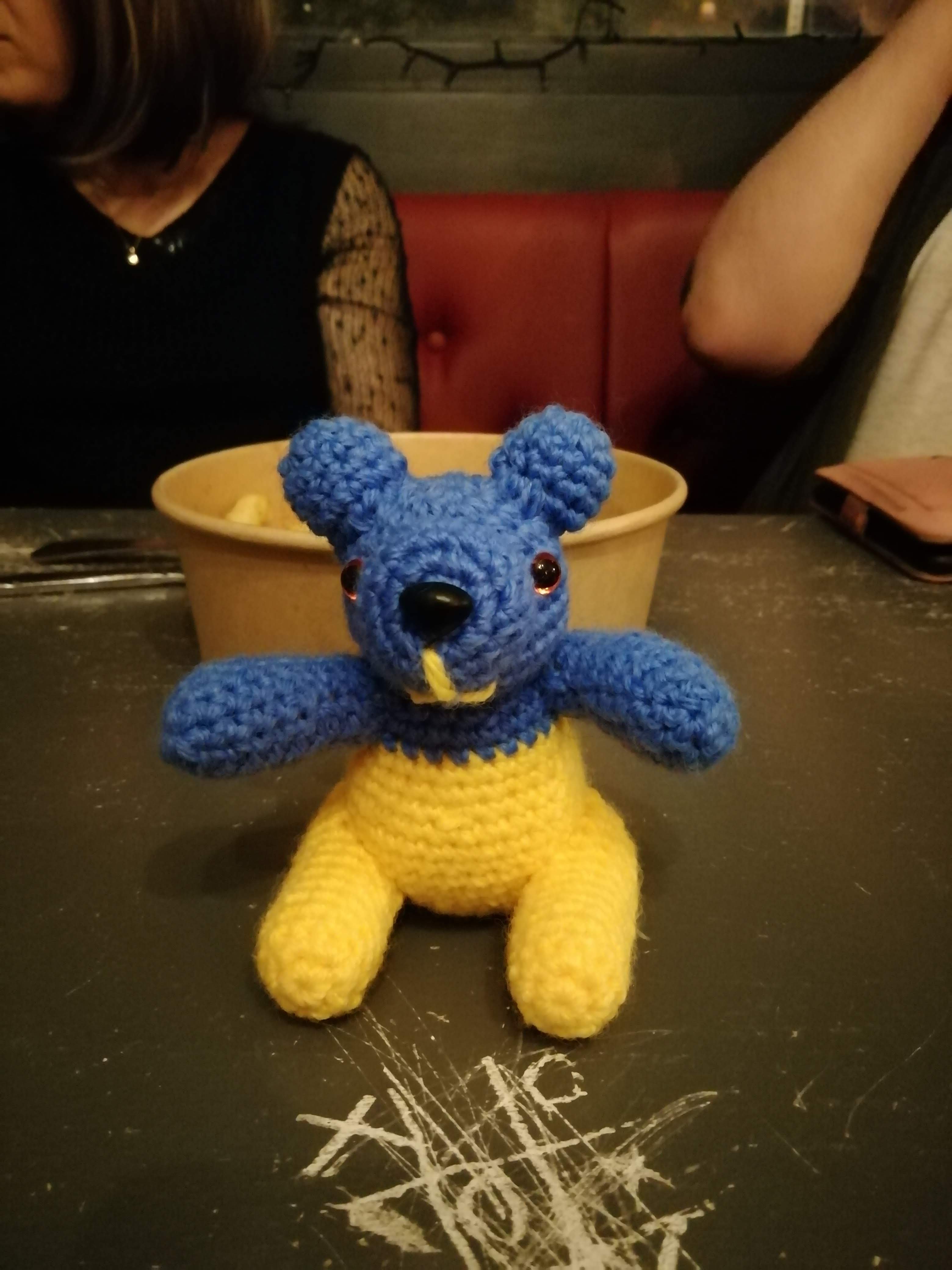 Blue and yellow panda on a table with chip basket