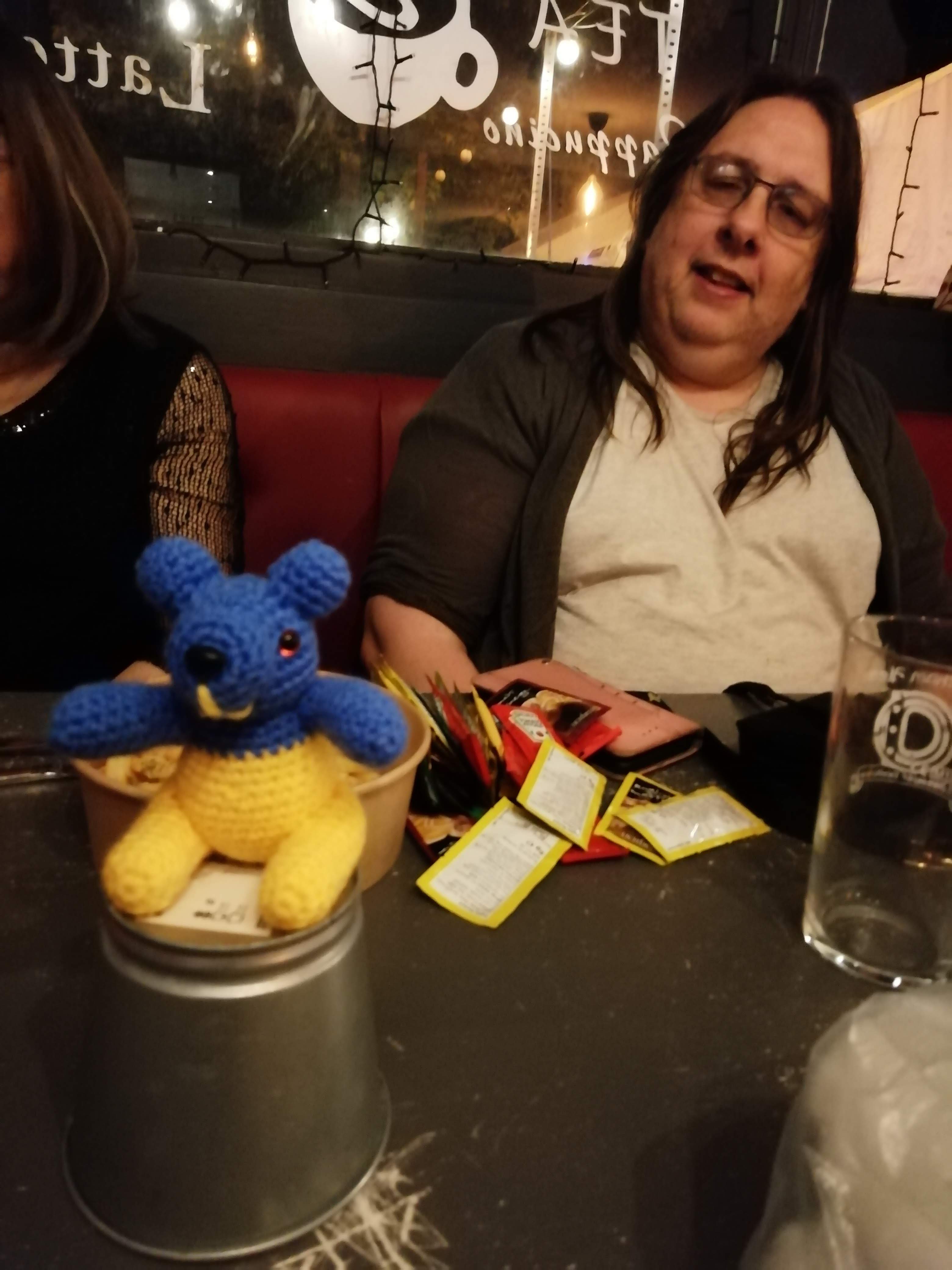 Blue and yellow panda on a table with Susan in background